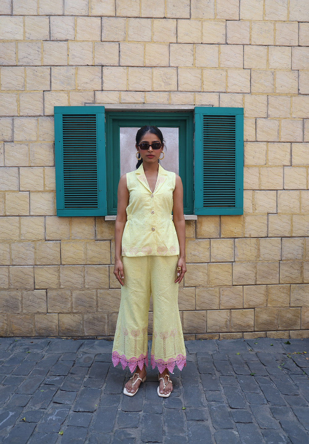 Model wearing pastel yellow palm embroidered coord set with sleeveless waistcoat and straight pants front view