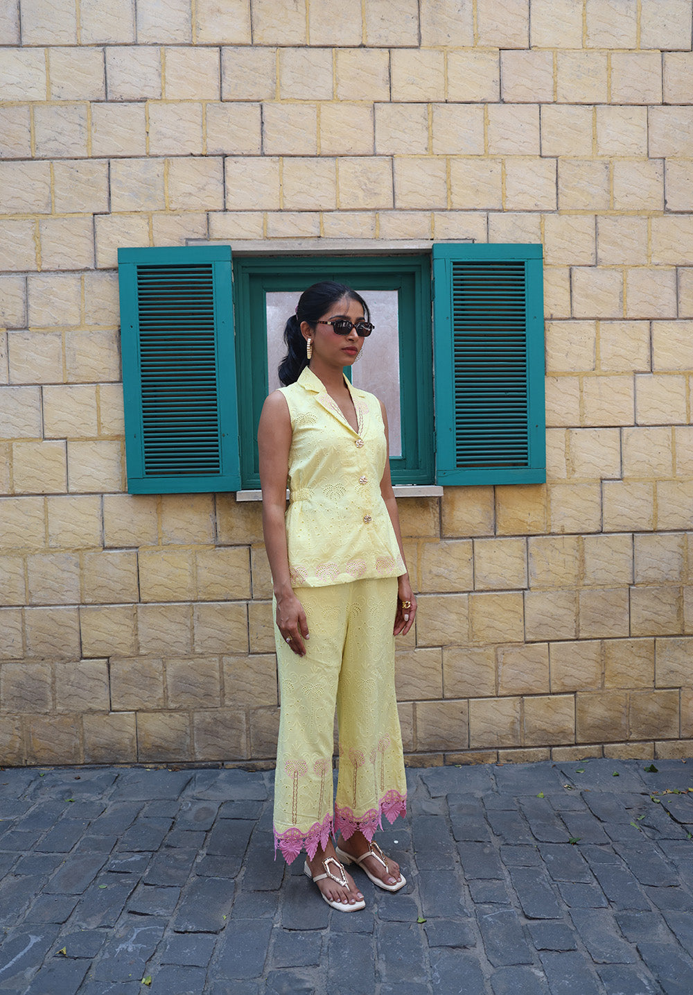 Side view of pastel yellow coord set with palm embroidery and pink lace hem detailing
