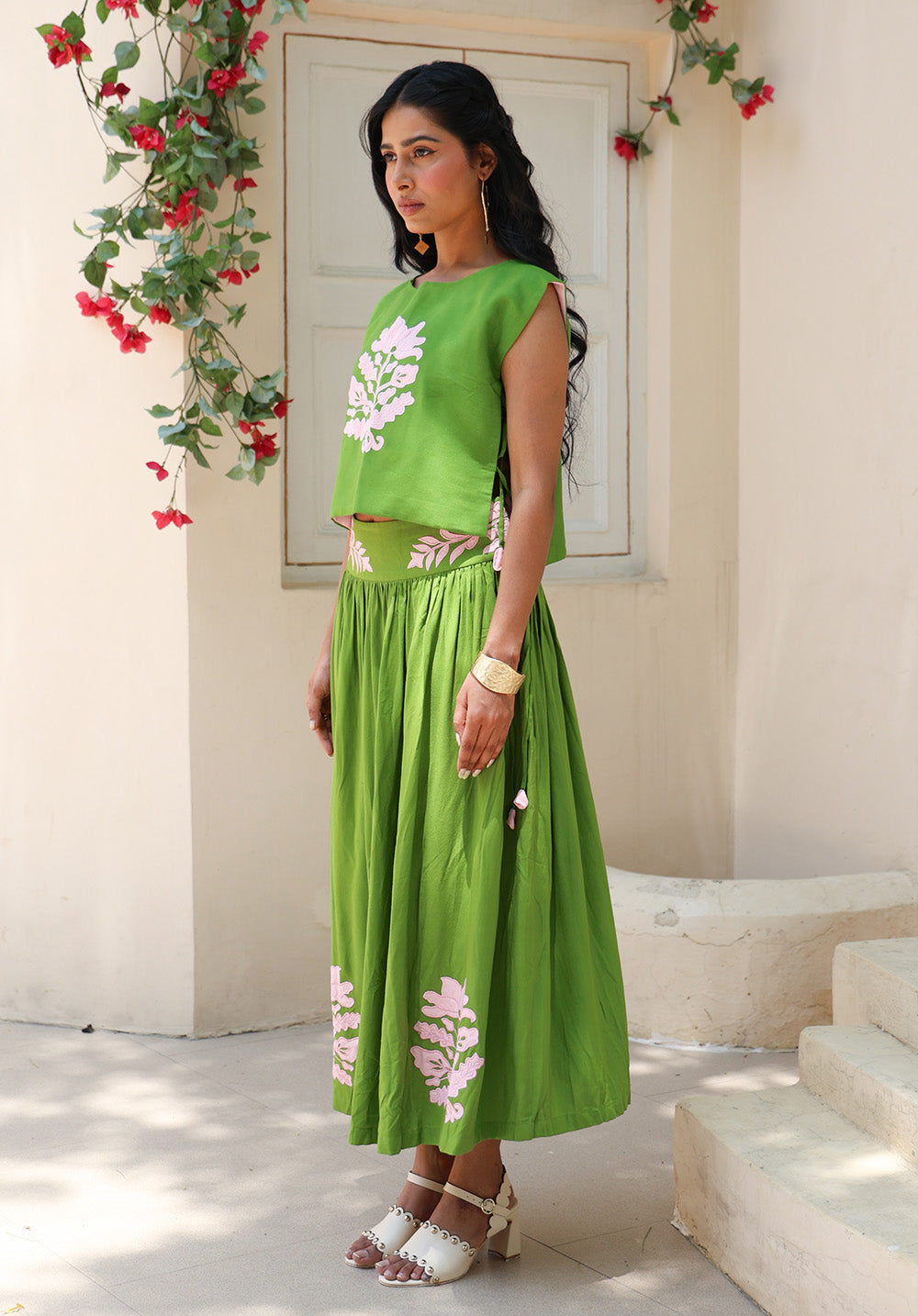Side view of the Olive Bloom coord set in soft green with blush floral appliqué and flowing gathered skirt.